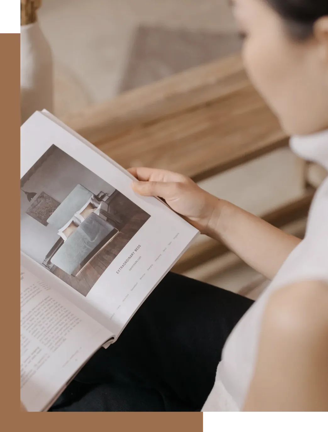 一位女士坐在木登上看杂志